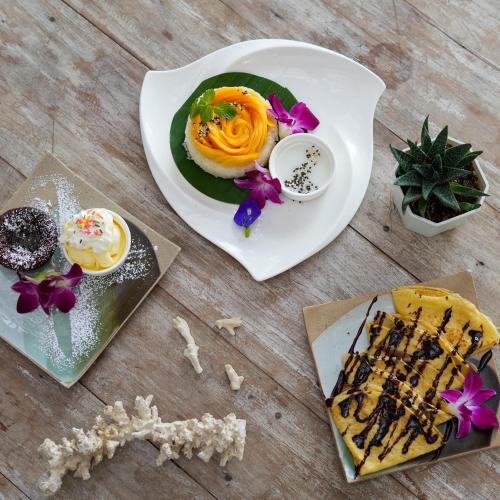 a plate of food on a wooden table with a dessert at Elephant Beach Club & Resort Samui in Chaweng