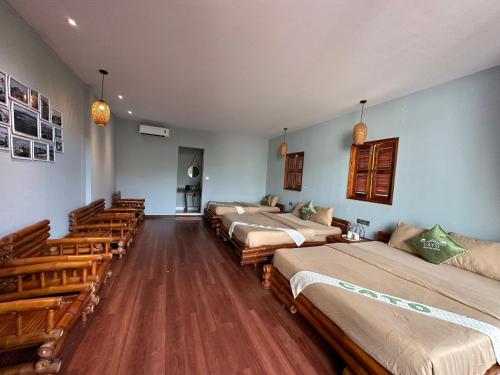 a row of beds in a room with pews at Cato Homestay in Can Tho