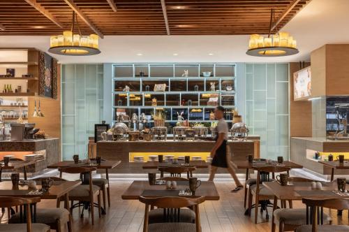 a woman walks through the dining room of a restaurant at Dusit Thani Manila in Manila