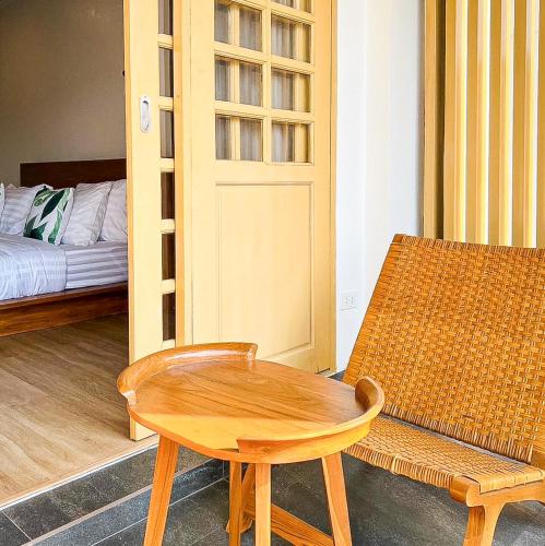 a room with a table and a chair and a bed at J Park Pakchong in Ban Sao Thong