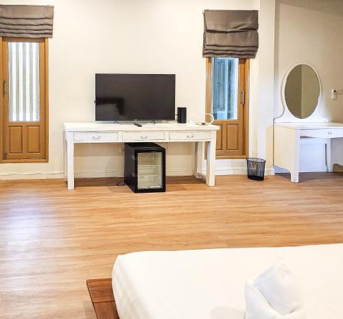 a bedroom with a white desk with a television at J Park Pakchong in Ban Sao Thong