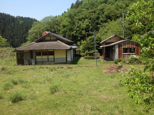 duas pequenas casas num campo com relva em Satoyama Guest House Couture em Ayabe