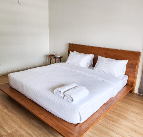 a bed with white sheets and towels on it at J Park Pakchong in Ban Sao Thong