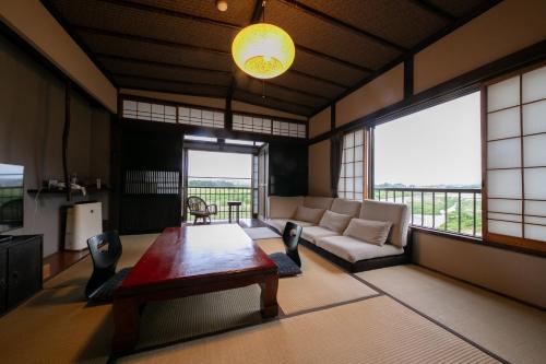 a living room with a table and a couch at Isamikan in Nakagawa