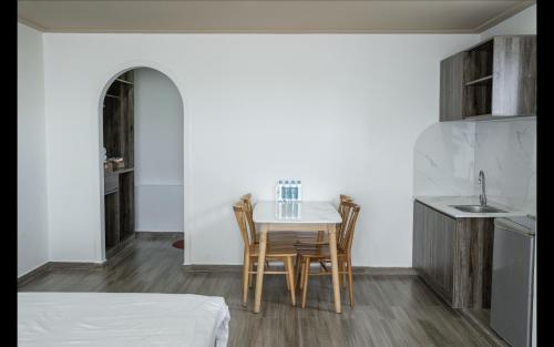 a kitchen with a table and chairs in a room at Camellia in Bao Loc