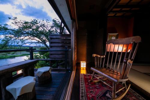 a rocking chair sitting on the porch of a house at Isamikan in Nakagawa