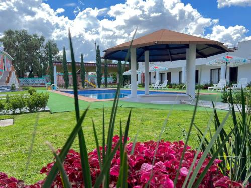 a garden with a swimming pool and a pavilion at Hotel El Jaguar in San Martín de las Pirámides