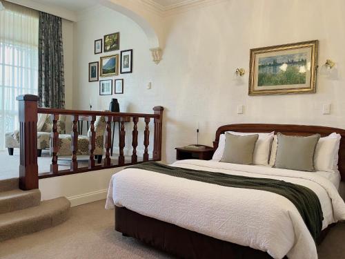 a bedroom with a large bed and a staircase at Victoria House Motor Inn in Croydon