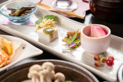 a table with two plates of food on a table at Isamikan in Nakagawa