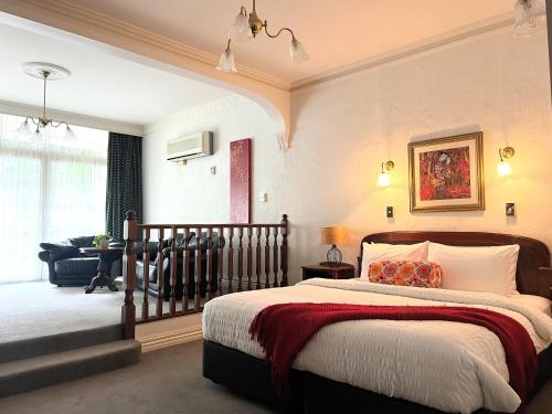 a bedroom with a bed and a living room at Victoria House Motor Inn in Croydon