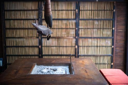 a bird is hanging from a hook in a room at Isamikan in Nakagawa