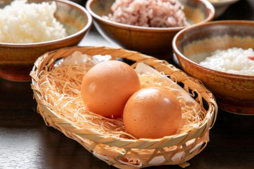 two eggs in a basket on a table with bowls of rice at Isamikan in Nakagawa