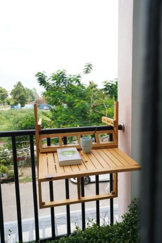 a wooden table on a balcony with a laptop at Sophia Healing House Cần Thơ in Can Tho