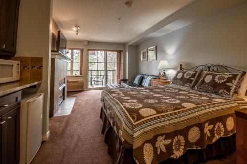 a bedroom with a bed and a living room at Borgata Lodge Resort in Kelowna
