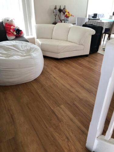 a living room with a white couch and wood floors at Sky BnB room with own bathroom in Gold Coast