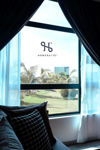 a window with a view of a palm tree at Homesuite' Home at Jesselton Quay in Kota Kinabalu
