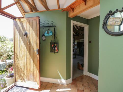 an open door in a room with green walls at The Old Byre in Salisbury