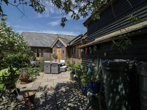 a backyard with a patio with plants and a house at The Old Byre in Salisbury