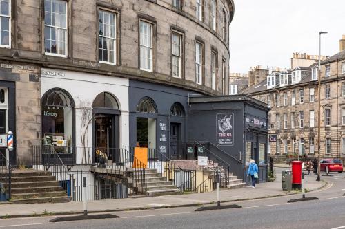 a building on a city street with a person walking past it at The Broughton Townhouse in Edinburgh