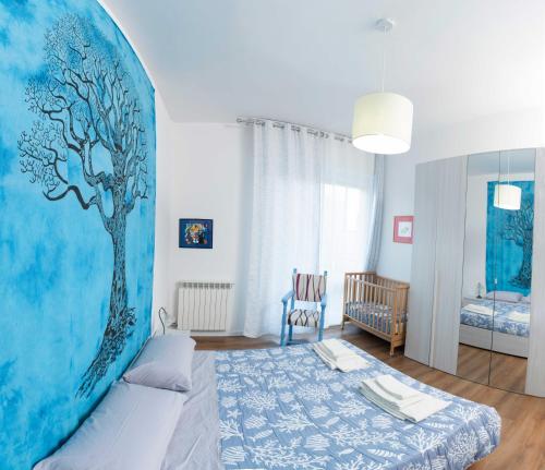 a bedroom with a tree mural on the wall at Casa Lorenza in Albisola Superiore