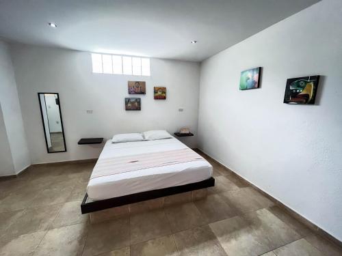 a bedroom with a large bed in a white room at Sunset Taganga Hotel in Taganga