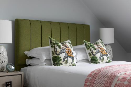 a bed with a green headboard and pillows on it at The Broughton Townhouse in Edinburgh