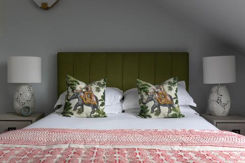 a bed with a green headboard and pillows on it at The Broughton Townhouse in Edinburgh