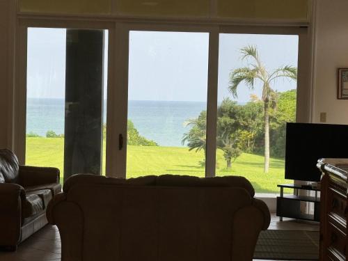 a living room with a view of the ocean at Beachfront Paradise Ishigaki in Ishigaki Island
