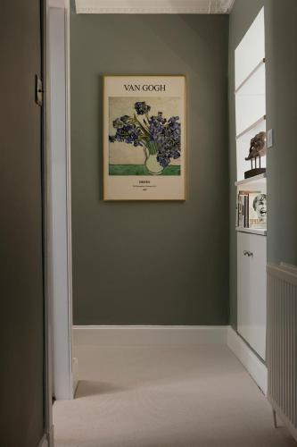 a hallway with a painting on a green wall at The Broughton Townhouse in Edinburgh