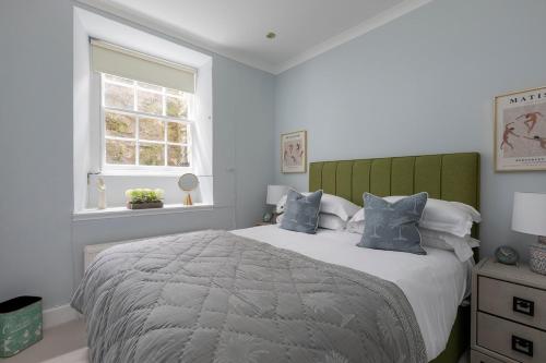 a bedroom with a large bed with blue pillows at The Broughton Townhouse in Edinburgh