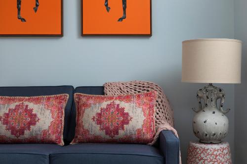 a blue couch with two pillows and a table with a lamp at The Broughton Townhouse in Edinburgh