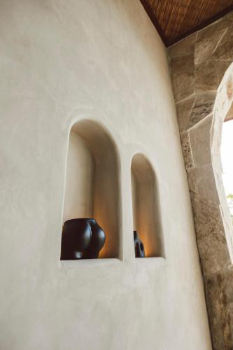 two black vases in a niche in a wall at SIVANA, Hotel Boutique with ocean or garden views - Adults only in Uluwatu