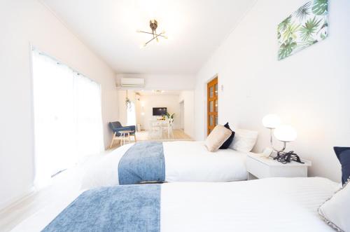 two beds in a room with white walls at Miraie Yokkaichi Aobacho in Yokkaichi