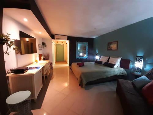 een grote slaapkamer met een bed en een bank bij ILET BLEU studio cosy RDC vue mer et jardin - Accès direct plage in Le Gosier