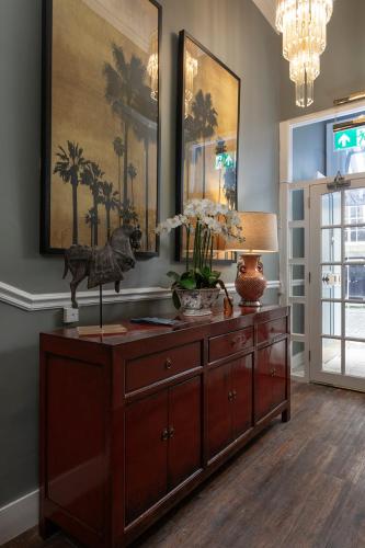 a living room with a wooden dresser and a lamp at The Broughton Townhouse in Edinburgh