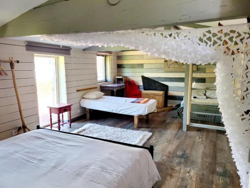 - une chambre avec un lit et une chambre avec une table dans l'établissement La cabane atypique, à Gujan-Mestras