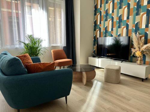 un salon avec une télévision, un canapé et une table dans l'établissement Le Cotin des Cordiers 1, F3 avec SA PLACE DE PARKING INCLUS, au Tréport