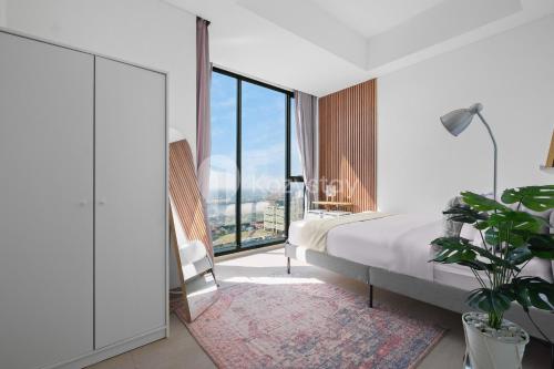a bedroom with a bed and a large window at Valoisa by Kozystay - Fatmawati in Jakarta