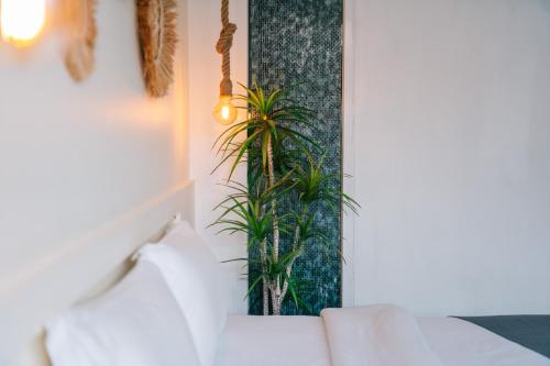 a room with a couch and two plants on a wall at Catnip Seaside Hotel&Cafe in Ban Huai Luk (1)