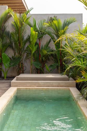 a swimming pool in front of a house with plants at SIVANA, Hotel Boutique with ocean or garden views - Adults only in Uluwatu