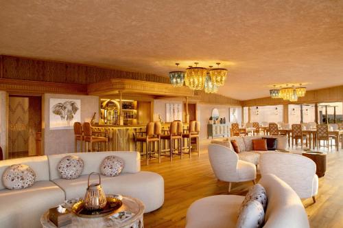 a living room with white couches and a bar at One Nature Mara River in Serengeti National Park