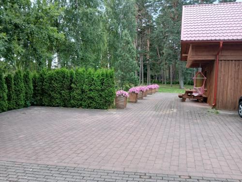 a brick walkway with pink flowers in a park at Guest house Vilciņi in Bernāti