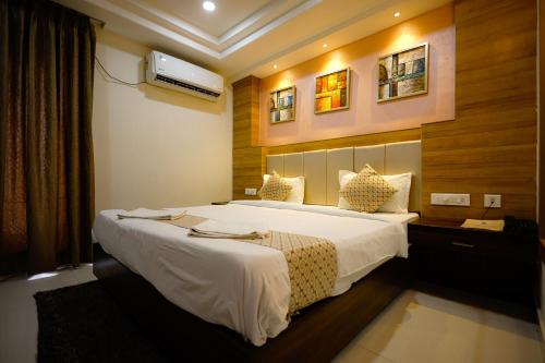 a bedroom with a large white bed in a room at M Square Hotel in Hyderabad