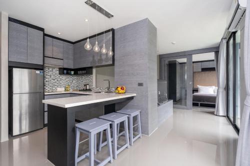 a kitchen with a large island with bar stools at Tropics Pool View 2BR Kamala Apartment CTG P605-6, near Beach in Kamala Beach