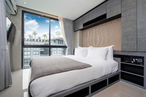 a bedroom with a large bed and a large window at Tropics Pool View 2BR Kamala Apartment CTG P605-6, near Beach in Kamala Beach