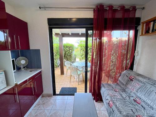 Il comprend un salon avec un canapé et une cuisine avec une terrasse. dans l'établissement Appartement T2 Rez-de-Jardin à Saint-Cyprien avec Accès Plage Direct et Piscine en Résidence - FR-1-753-22, à Saint-Cyprien