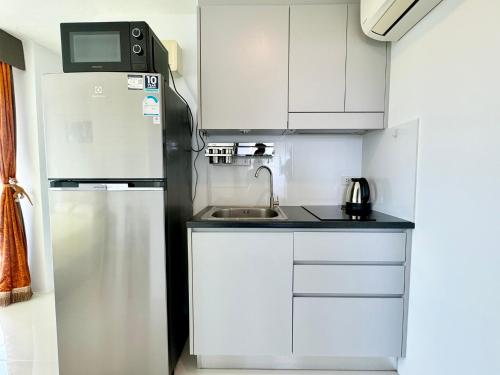 a small kitchen with a sink and a refrigerator at Mantra Beach Condominium Suite - Mae Phim in Ban Tha Fat