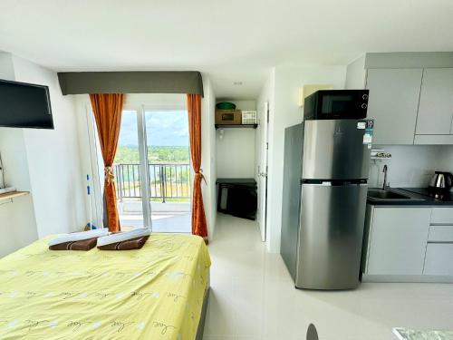 a kitchen with a bed and a refrigerator in a room at Mantra Beach Condominium Suite - Mae Phim in Ban Tha Fat