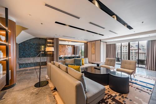 a living room with couches and a table at Palm Garden Hotel, Putrajaya, a Tribute Portfolio Hotel in Putrajaya