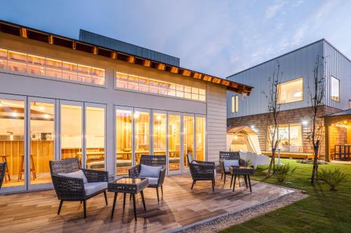a patio with chairs and tables in front of a building at NAGAHAMA lifestyle glamping hotel in Nagahama